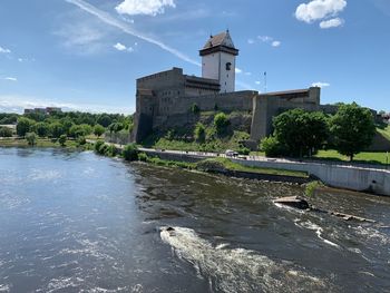 Building by river against sky