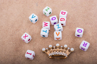 High angle view of multi colored letters and jewelry on table