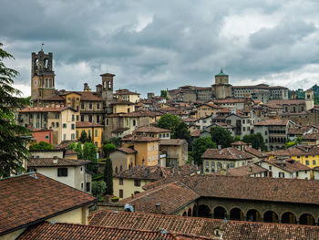 Buildings in town against cloudy sky