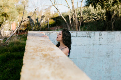 Beautiful woman standing at abandoned swimming pool