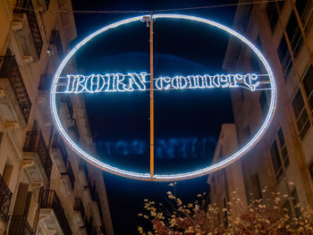 Low angle view of illuminated sign at night