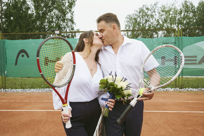 The newlyweds play tennis on the court symbolizing family relations