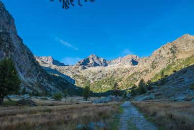 Scenic view of landscape and mountains against blue sky