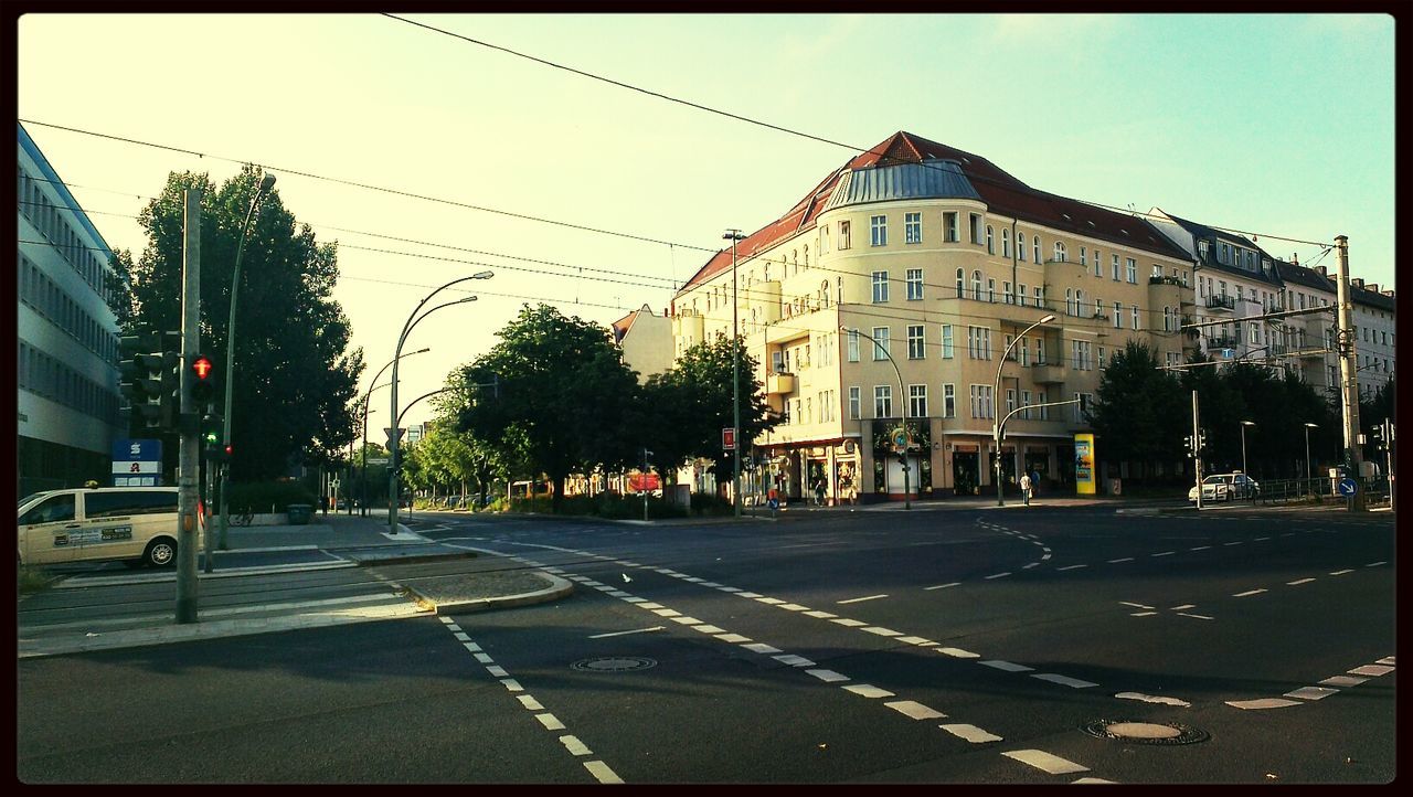 building exterior, architecture, street, built structure, transfer print, road, transportation, road marking, city, auto post production filter, car, city street, clear sky, street light, sky, the way forward, tree, building, land vehicle, outdoors