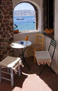 Chairs and table on chair by sea