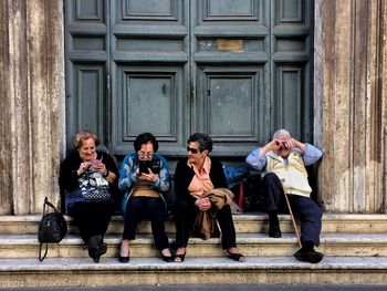 Group of people sitting at entrance of building