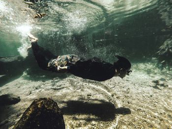 Side view of man swimming undersea