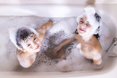 High angle portrait of smiling siblings in bathroom