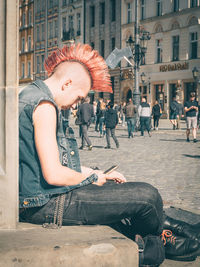 Woman sitting on street in city