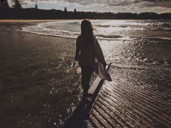 Rear view of woman walking on beach