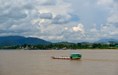 Boat in sea against mountains