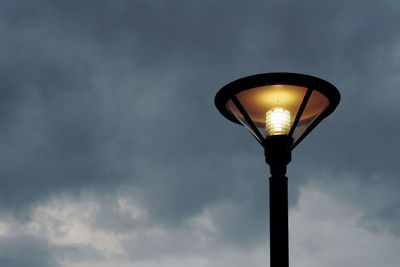 Low angle view of illuminated street light against sky