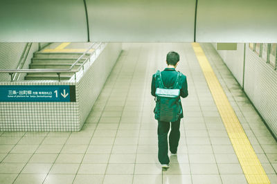 Rear view of man standing at subway station