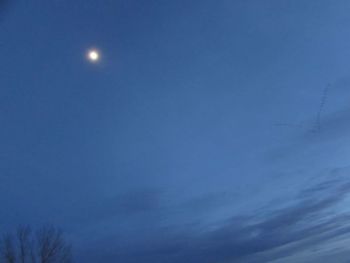 Low angle view of moon against blue sky