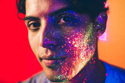 Portrait of man with multi colored face paint