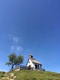 Church on field against clear blue sky