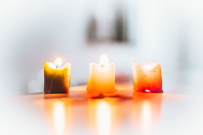 Close-up of lit candles on table