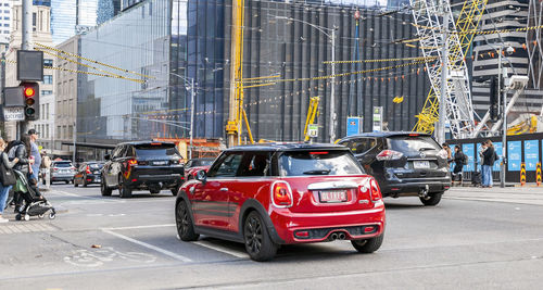 Traffic on road by buildings in city
