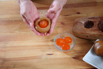 Close-up of hand holding ice cream on cutting board