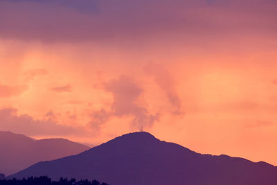 Scenic view of silhouette mountains against romantic sky at sunset
