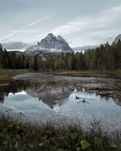 Scenic view of lake by mountains against sky