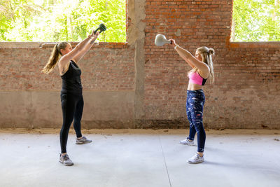 Young adult fitness women doing swing exercise with a kettlebell as a part of a fitness workout. 