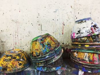 Close-up of multi colored pencils on table against wall