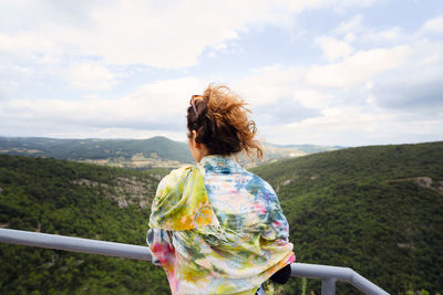 Rear view of woman looking at mountain against sky