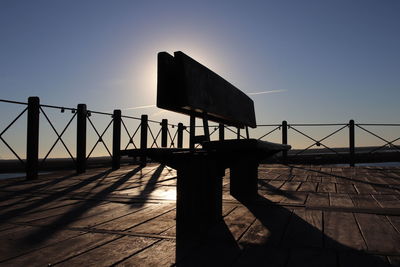 Silhouette bridge against clear sky at sunset