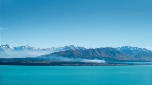 Scenic view of snowcapped mountains against blue sky
