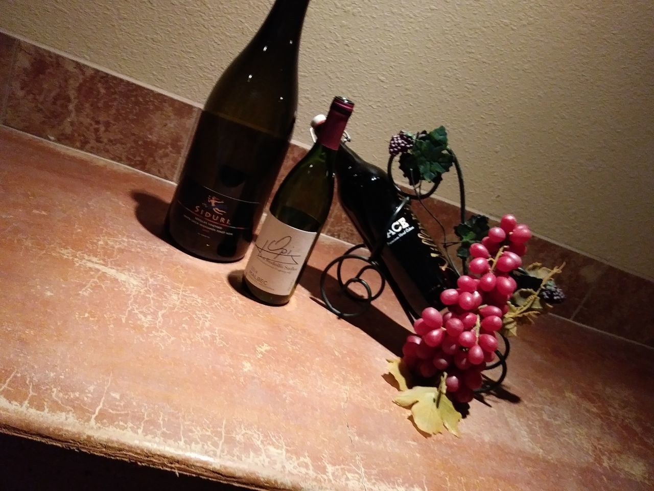 CLOSE-UP OF RED WINE WITH BOTTLE ON TABLE