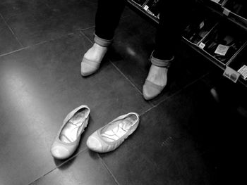 Low section of person standing on tiled floor