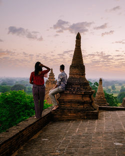 Tourists at temple against sky