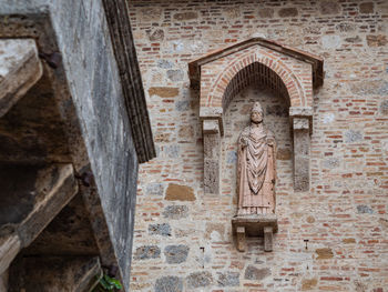 Religious high relief of a saint on the external wall in san gimignano italy