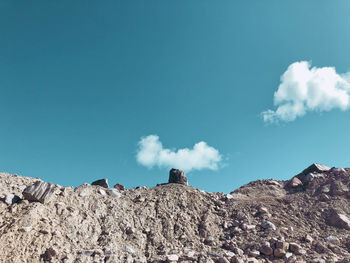 Low angle view of rocks against blue sky