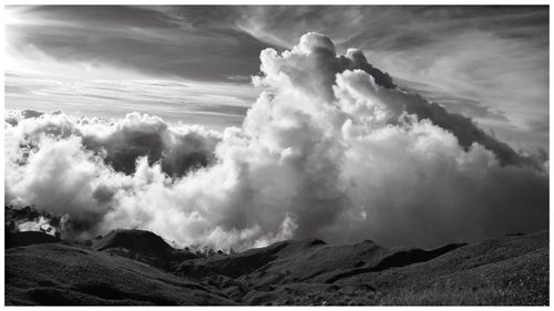 Scenic view of mountains against cloudy sky