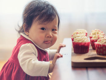 Portrait of cute girl with cupcakes