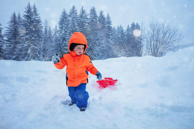 Portrait of boy skiing on snow covered field