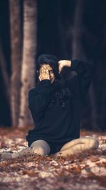 Midsection of woman in forest during autumn