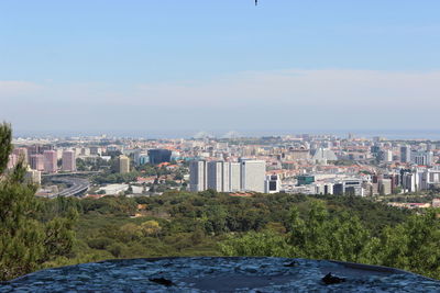 Cityscape by sea against sky