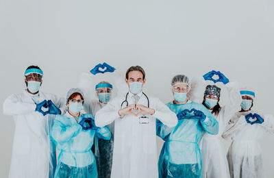 Doctors wearing mask standing against white background