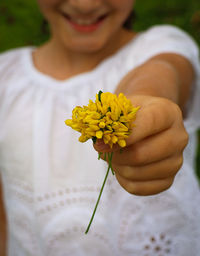 Midsection of woman holding yellow flower