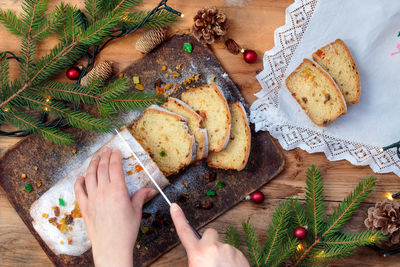 High angle view of hands slicing cake