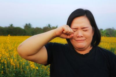 Portrait of woman on field against sky