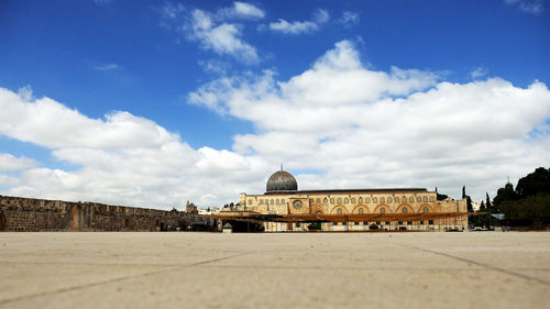 Town square in front of historic buildings against cloudy sky