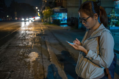 Young woman using mobile phone in city