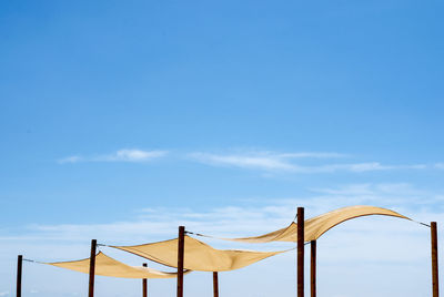 Low angle view of metallic structure against blue sky