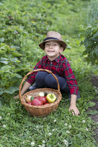 Portrait of smiling young woman standing by plants