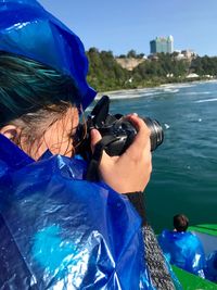 Woman photographing sea in city