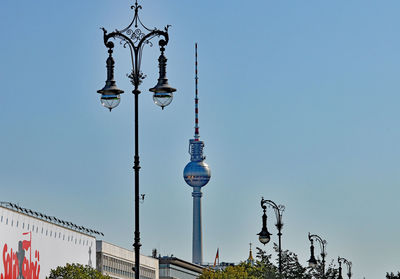 Low angle view of antique street lights and fernsehturm against sky